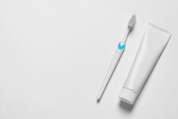 Plastic toothbrush and paste on white background, top view. Space for text