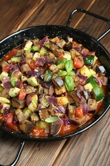Delicious ratatouille in baking dish on wooden table, closeup
