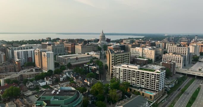 Flying backwards above Madison downtown buildings, and road by the Lake Monona, Wisconsin