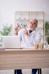 Old male doctor holding molecular model