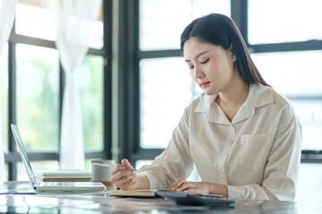 Obraz premium Beautiful young businesswoman working with financial reports at her workplace.