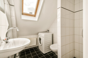 a bathroom with black and white tiles on the floor, shower stall and toilet in the photo is taken to the other side