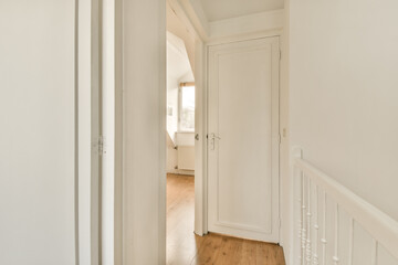 Fototapeta premium a hallway with white walls and wood flooring in an empty house, taken from the front door to the entrance way