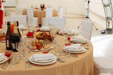 The catering table set service with silverware and glass stemware at a restaurant before the party. Selective focus on the champagne glasses