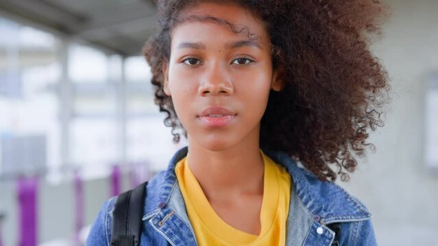 Attractive african american black teenager girl standing in the city, looking at camera