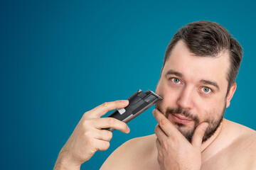 unshaven young man perfect skin hold electric razor shaving, isolated. Skin care healthcare...