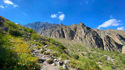 Fototapeta premium A rocky trail in the mountains of Kyrgyzstan. Ala Archa National Park. Majestic cliffs, ridges, peaks and mountains of Kyrgyzstan. Beautiful mountain landscape.