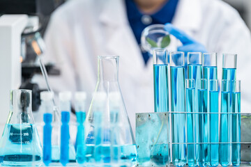 laboratory glassware equipment for medicals science chemistry research, blue liquid in scientific glasses flask, test tube, and beaker for chemical medicine experiment or biology technology analysis