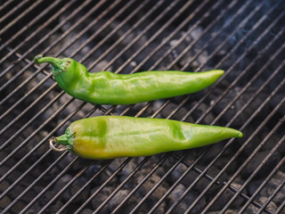 Grilling two peppers outside on a bbq