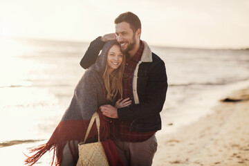 Young caucasian couple walking on the beach during winter and colder weather