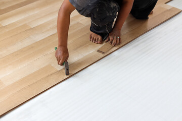 worker joining vinyl floor covering at home renovation