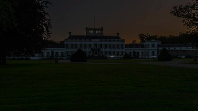 Time lapse of the sun rising behind a beautiful white palace in the Netherlands - slow zoom out
