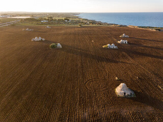 Polignano a mare: Plowed field with trulli