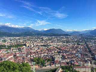 Fototapeta na wymiar Aerial view of Grenoble old town seen from Bastille Fort, Auvergne-Rhone-Alpes region, France, Europe. View from above on the Isere Valley in the French Pre-Alps. Chartreuse Belledonne mountain range
