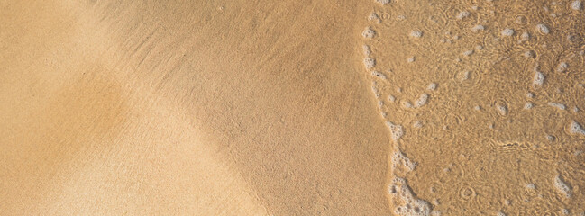 Beach sand background with wave. Copy space for your text advertisement. Soft sea ocean transparent water waves. Minimal concept