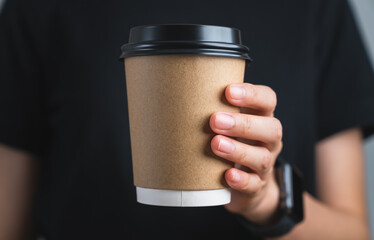 Hand holding blank kraft paper coffee cup for takeaway, delivery concept.