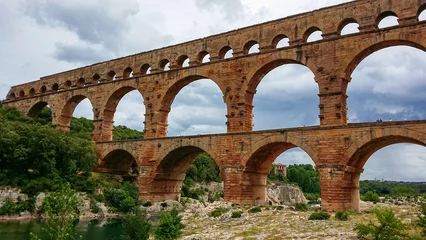 Photo sur Plexiglas Pont du Gard Panoramic view of ancient old Roman Aqueduct Pont du Gard ear Vers-Pon-du-Gard, Occitanie, France, Europe. Landmark over the River Gardon. Unesco world heritage site near Nimes, Languedoc-Roussillon