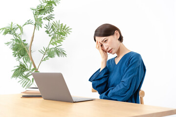 パソコンの前で悩む女性