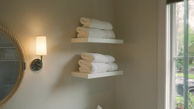 Neatly folded white towels on bathroom shelf