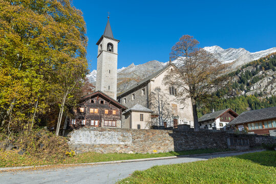 Picturesque old mountain church in autumn. Traditional alpine village of Macugnaga, Piedmont, Italy. European alps. Parish Church of Santa Maria Assunta and San Giuseppe