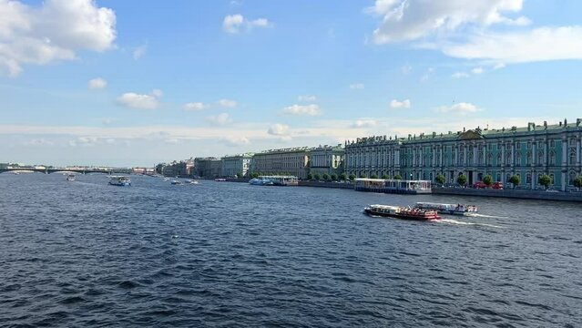 View of the Neva River against the background of the Hermitage in St. Petersburg, Russia. Ferries and boats sail along the river. Saint Petersburg city tour