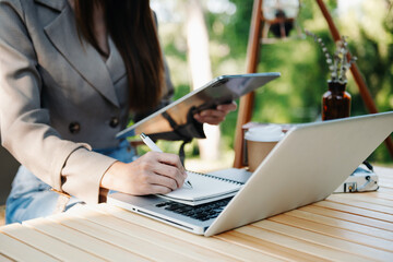 Fototapeta premium Businesswoman using mobile phone, tablet.Closeup on blurred green background..