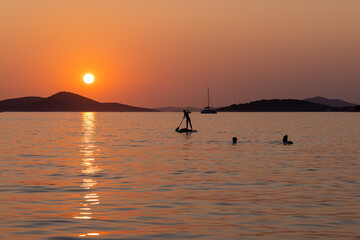 Sunset on the Adriatic Sea in Croatia, with the people swimming
