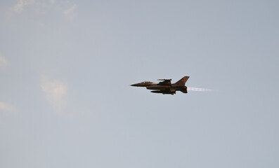 Bucharest International Air Show. F16 military fighter airplane flying against sunset sky. Military aviation aircrafts and war missiles industry.