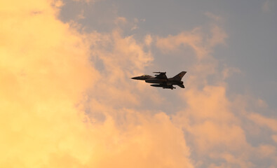 Bucharest International Air Show. F16 military fighter airplane flying against sunset sky. Military aviation aircrafts and war missiles industry.