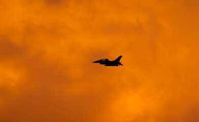Fototapeta na wymiar Bucharest International Air Show. F16 military fighter airplane flying against sunset sky. Military aviation aircrafts and war missiles industry.