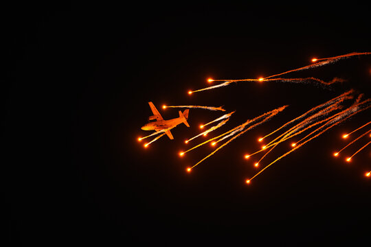 C27J Spartan military aircraft throwing rockets missiles during a night exercise part of Bucharest International Air show. Military aviation industry concept image