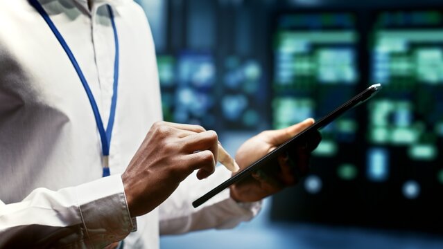 Close up of skillful engineer doing inspection in blockchain technology application specific integrated circuit data center. Experienced technician working in mining facility