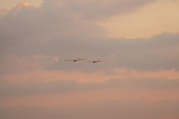 Two air glider flying against sunset sky, part of White Wings team, during Bucharest International Air Show.