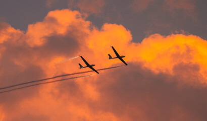 Two air glider flying against sunset sky, part of White Wings team, during Bucharest International Air Show.