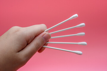 Białe patyczki do czyszczenia uszu trzymane w dłoni 
