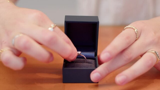 Diamond ring put in a box and closed by woman's hands