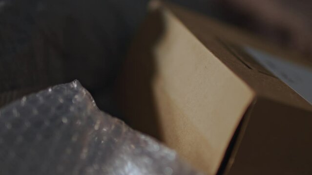 Close shot of a package near some bubble wrap lean somewhere. Few light and shallow depth of field
