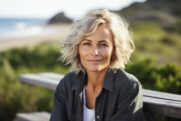 Portrait of a middle-aged woman sitting on a bench at the beach