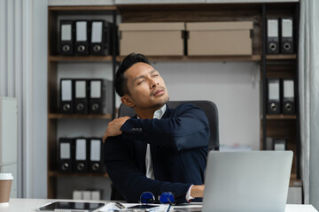 Male businessman is doing a stretchy posture due to sitting in the office for too long, office syndrome concept. - obrazy, fototapety, plakaty