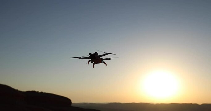 Drone flying against sunset sky