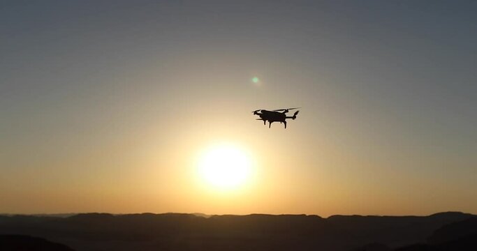 Drone flying against sunset sky
