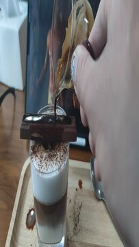 Pouring coffee into the cup, Broken bridge coffee, hot milk, chocolate on top, melting chocolate dropped into the coffee, dipping hot coffee shot. High quality 4k footage