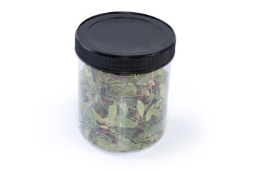 Dried leaves and fruits of cowberry in closed plastic container