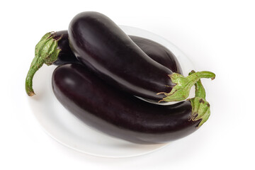 Raw freshly harvested purple eggplants on dish on white background
