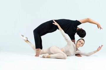 Ballet Concepts. Asian Young Man and Caucasian Woman Performing As Ballet Dancers Over Grey Studio Background Doing Suppots As Classical Dance Aesthetics With Choreography Art © danmorgan12