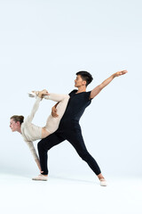 Ballet Concepts. Asian Young Man and Caucasian Woman Performing As Ballet Dancers Over Grey Studio Backdrop During Suppots As Classical Dance Aesthetics © danmorgan12