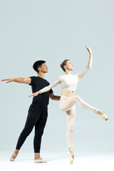 Ballet Concepts. Asian Young Man and Caucasian Woman Performing As Ballet Dancers Over Grey Studio Background Doing Suppots © danmorgan12