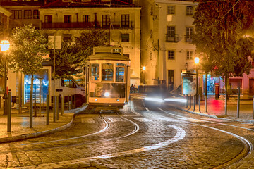 Traditional Lisbon Yellow Tram on Street of Alfama District in Portugal At Night Time.