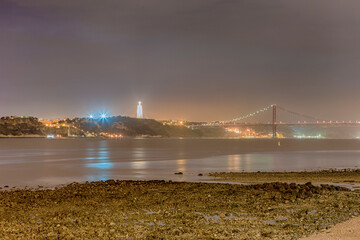 25 April Suspension Bridge Over the Tagus River and Almada Christ in Lisbon in Portugal At Night