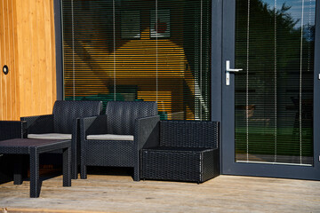 Relax corner with garden furniture at house terrace. Lounge zone in modern family house